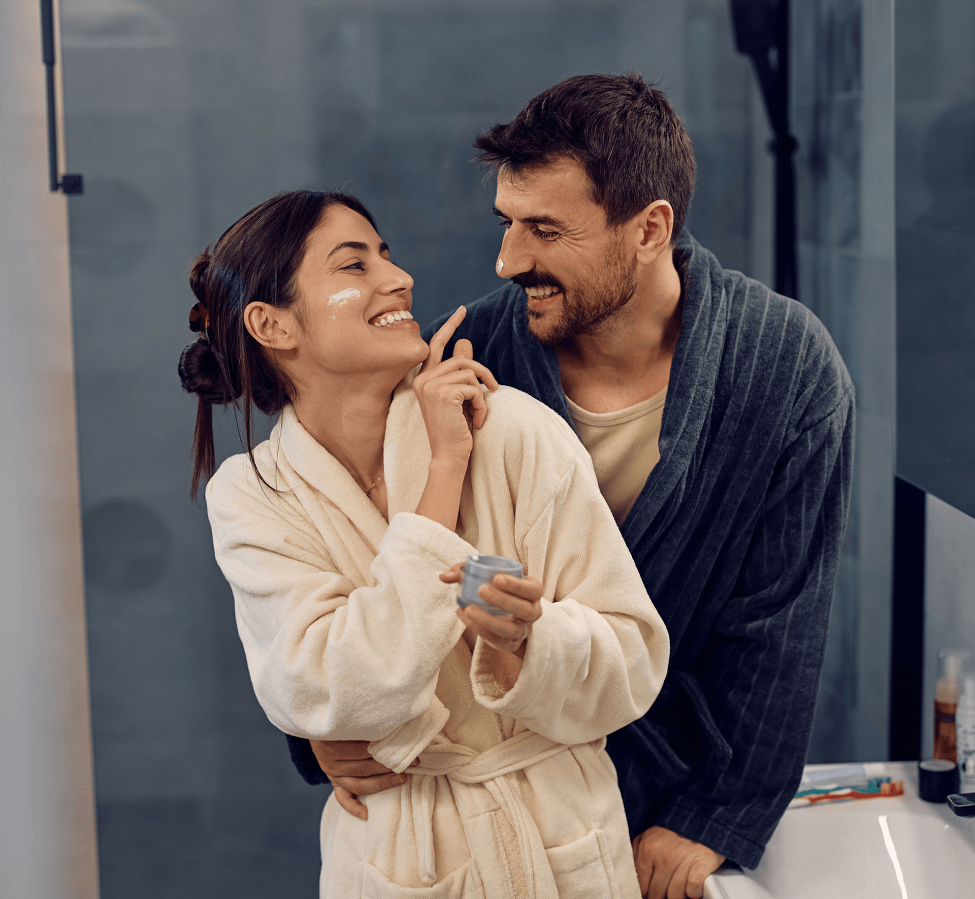 Man and woman smiling in bathrobes